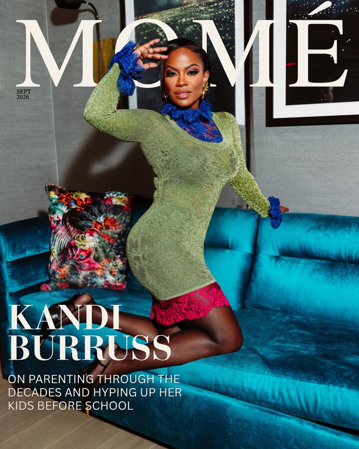 Momé September 2026 cover &mdash; Kandi Burruss kneels on a teal velvet sofa in a green metallic mini dress with blue lace cuffs and collar.
