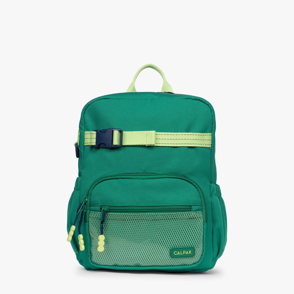 The CALPAK Kids Small Backpack in green, shown from the front with a lime carry handle, a lime chest strap with navy buckle, and a mesh front pocket.