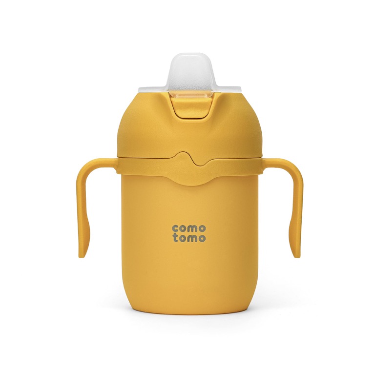 Comotomo silicone sippy cup in mustard yellow with two removable handles and a soft spout.