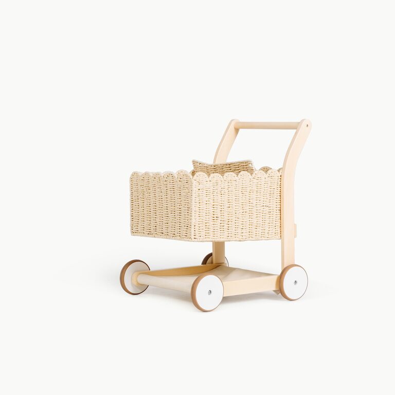 A toddler-sized wooden shopping cart with a scalloped woven-paper basket, a small woven seat, a curved wooden handle and four white-and-wood wheels, on a white background.