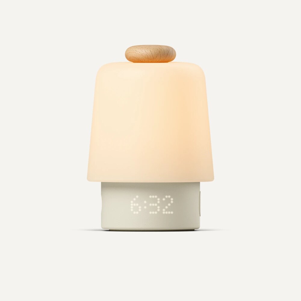 The Hatch Baby sound machine and night light, glowing warm with a 6:32 time display.